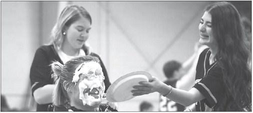 PALMER MUSIC INSTRUCTOR ANNA SAKE fell victim to the Palmer PTO’s change war fundraiser on Friday night when, during halftime of the Tigers’ game against Archangels Catholic, Sake received a pair of pies to the face. Lending a hand were Dianna Lockwood and Eden Kucera. Photo by Jordan Coslor