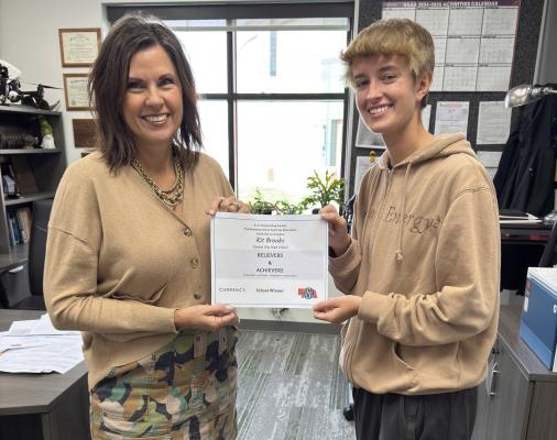 Top Of The Top Central City High School counselor Mrs. Ann Greving-Brown presents Kit Brooks with her award from the NSAA.