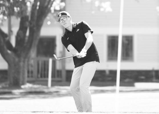 LOGAN VAKINER chips a shot onto the green at Indianhead Golf Club during the Grand Island Central Catholic Invite. Vakiner ended the day with a score of ninety-nine. Photos by Jordan Coslor