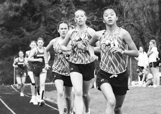 GRACE NOKELBY leads the pack in the 3200-meter run, followed closely by teammates Ava Brumbaugh and Addie Edson. Photo by Jordan Coslor