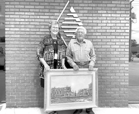 Central City native Todd A Williams beautifully captured the state of Nebraska and on multiple occasions has captured the history of Merrick County. One of those works of art has a new home as Deb Beck of Pinnacle Bank presented the work of art to Bill Bolte and the Merrick County Historical Museum.