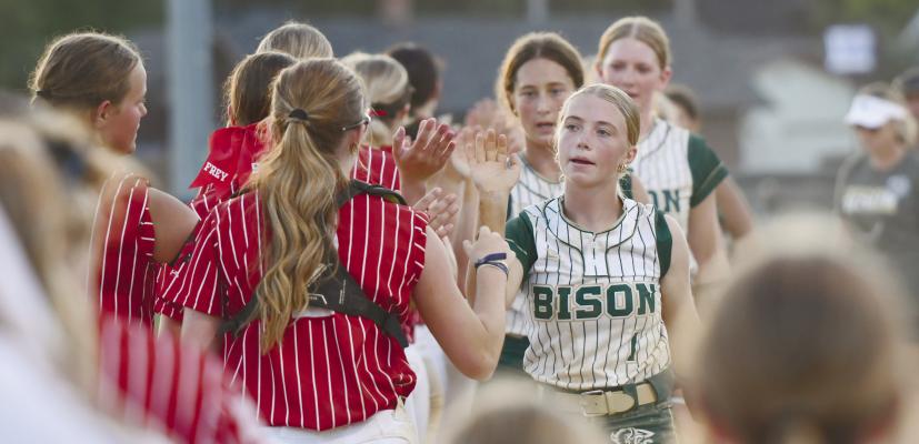 CENTRAL CITY’S EMMA BRANDES exchanges a high-five with a Cardinal player following last week’s season opener for Central City softball. In their first outing of the fall, the Bison defeated the Cardinals 9-1, thanks, in part, to a strong performance at the plate. Photo by Jordan Coslor