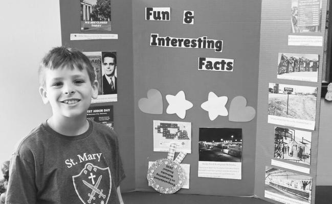 FOURTH-GRADER MAX RONHOVDE shows off the Nebraska Studies presentation he created using, in part, the All Things Nebraska website. A map pulled from the website is pasted on the bottom left of the poster. Courtesy Photo