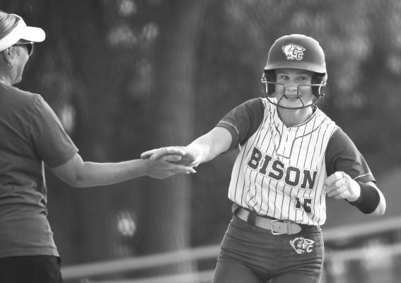ADDIE BURBACH rounds third base and high fives Head Coach Neely Moser after hitting a home run in the first inning of Central City’s 12-0 win over NEN. Photo by Jordan Coslor