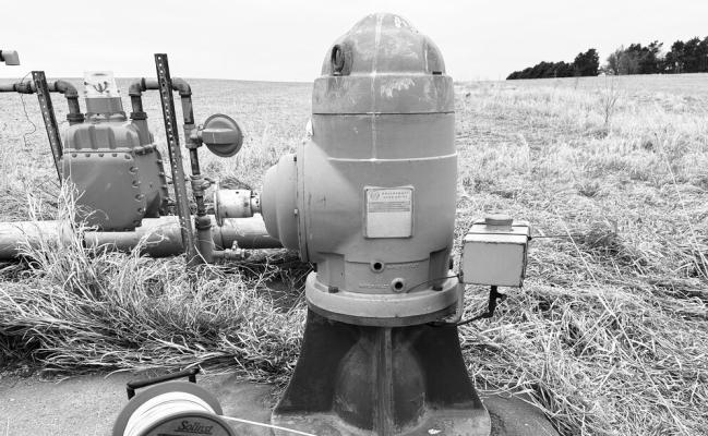 A WELL MEASURING TAPE is positioned next to an irrigation well head in preparation for making a water level measurement. Courtesy Photo