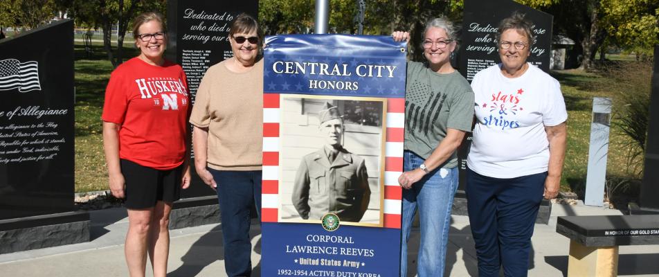 A Tradition is Born Ann Heinen, Vicki Fishler, Natalie Foulk and Helen Foulk show off the large veteran banners that will soon go up in Central City.