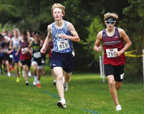 NEBRASKA CHRISTIAN’S JACOB SWANSON takes a lead over Doniphan-Trumbull’s Kaser Johnson in the first mile of the NSAA Class D State Cross Country Championships last Friday. Swanson would go on to his third consecutive fourth place finish in the race. Photos by Jordan Coslor