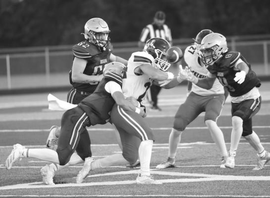 QUINN JENSEN and Broc Rathbone combine for a tackle. Jensen ripped the ball loose on the tackle, forcing a fumble on the first Adams Central drive of the game. Photos by Michael Happ