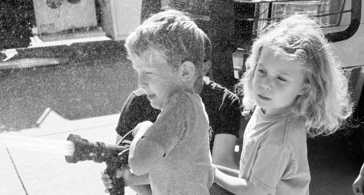 DEAN SCHNEIDER AND PHOEBE CRAWFORD help spray the fire hose during last week’s Fire Prevention Week activities at Palmer Public Schools. Courtesy Photo