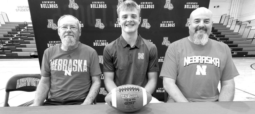 We may have missed out on Carter Nelson (middle) in the Central City green and gold, but he recently announced he will be a Nebraska Cornhusker. The Ainsworth football standout is flanked by his grandfather Harold (left) and father Jake (right). (Photo Courtesy of Bob Jensen)