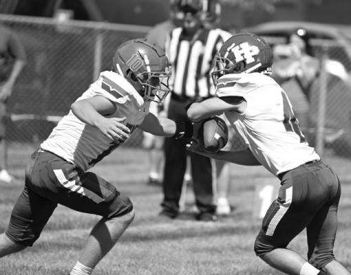 HIGH PLAINS quarterback Carson Swedenburg hands the ball off to Aaron Brown in the Storm’s 58-0 victory over Elba. Photos by Michael Happ