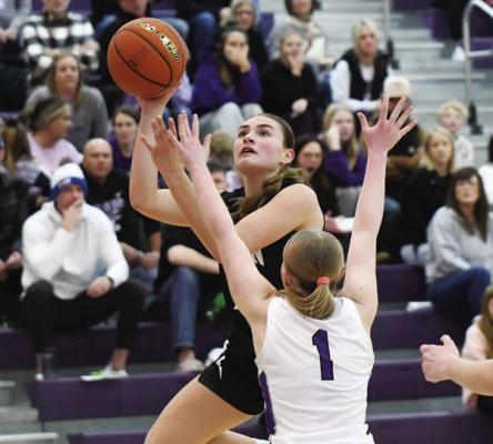 SYDNI HOMOLKA scores in the paint over Milford’s Kylie Jakub. Homolka scored twenty-three points to lead all scorers in Central City’s subdistrict final game with the Eagles. Photos by Jordan Coslor
