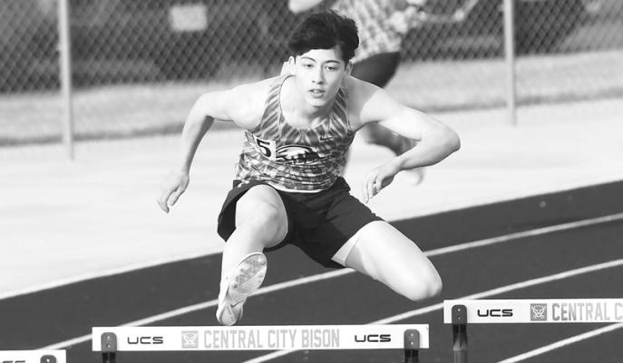 TUCKER SCHREIBER comes around the final turn in the 300-meter hurdles at last week’s Merrick County Invite. Schreiber finished fourth in the race with a time of 46.15 seconds.