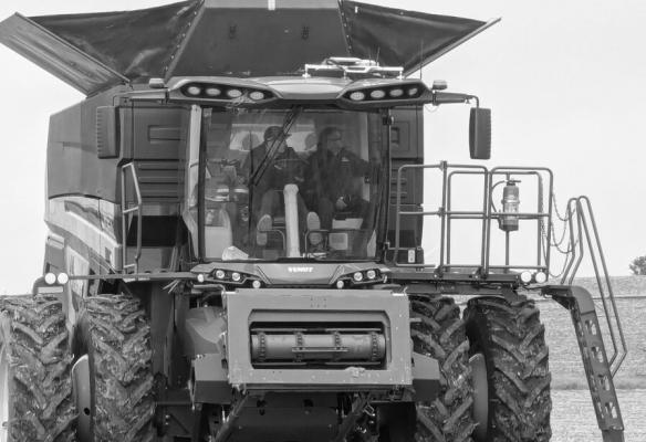 SANTOSH PITLA (right), professor of biological systems engineering, rides in a tractor at the grand opening of PTx Trimble’s facility in Seward last spring. Courtesy Photo