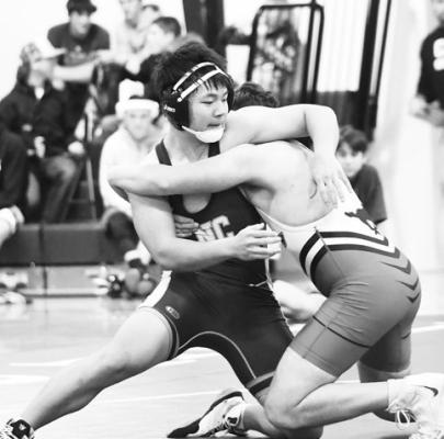 ZAK ZHANG wrestles with Sutton’s Brayden Griess in last Tuesday’s triangular at Nebraska Christian Public Schools. Photo by Jordan Coslor