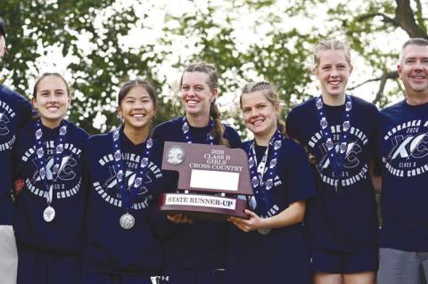 NEBRASKA CHRISTIAN placed second in the Class D girls race at last week’s NSAA State Cross Country Championships. Pictured with the runner-up trophy on Friday are Head Coach Dan Sanborn, Adelyn Edson, Grace Nokelby, Adelain Mankin, McKinley Mankin, Eliza Sanborn, and Assistant Coach Travis Powell. Photos by Michael Happ