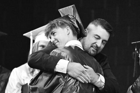 EVERETT HUNNICUTT embraces his dad Zach, who helped distribute diplomas to the members of the Class of 2026 during Saturday’s commencement exercises at Nebraska Christian Schools. Photos by Michael Happ
